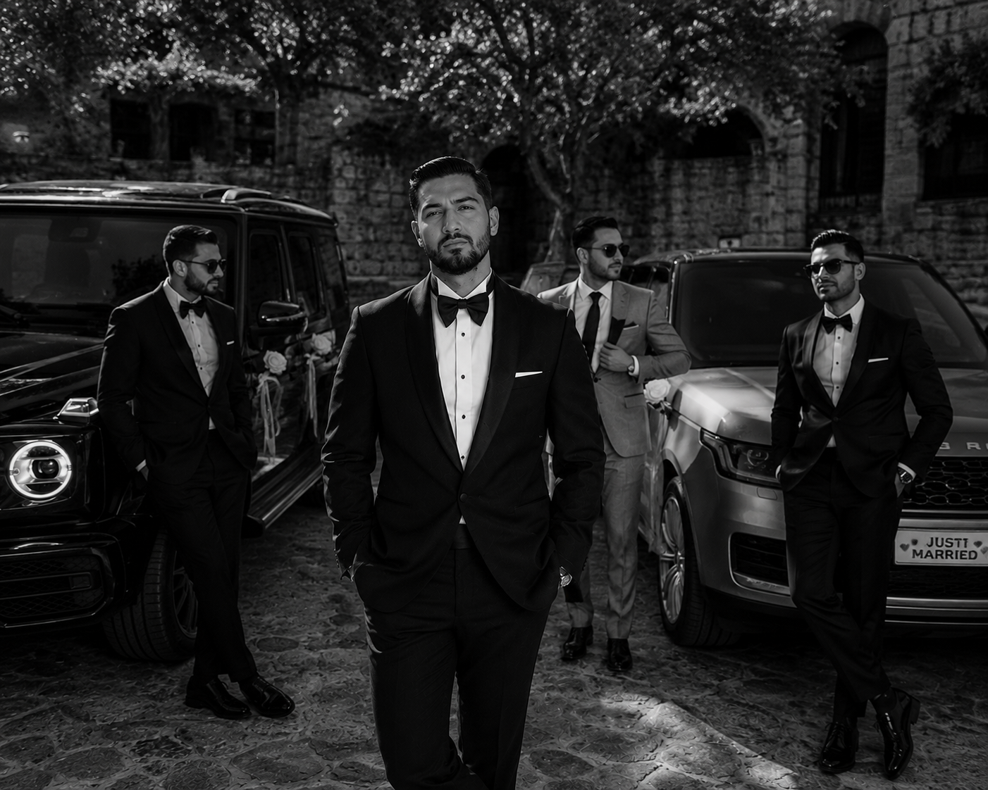 Groomsmen standing between wedding cars